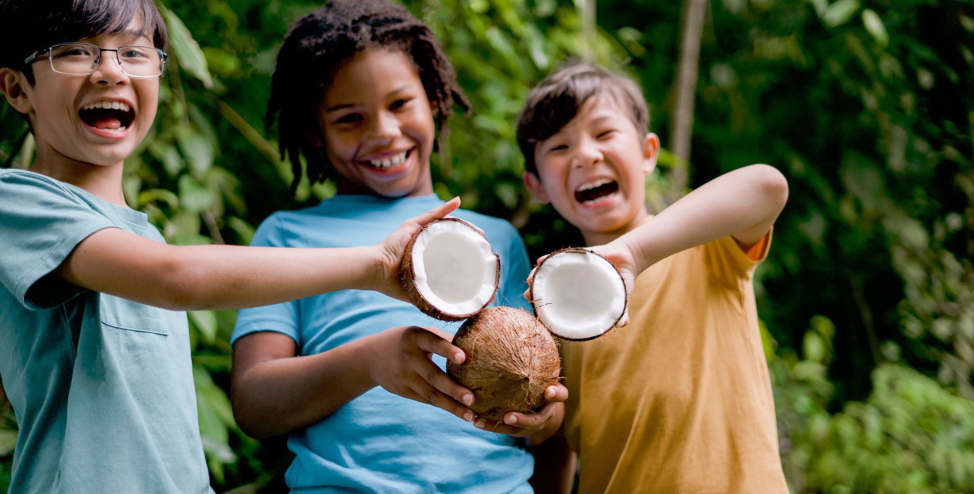 kids in costa rica making mickey mouse face with coconuts