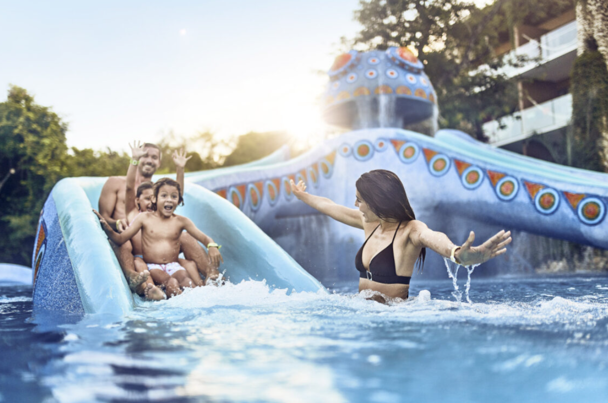 family in pool on waterslide