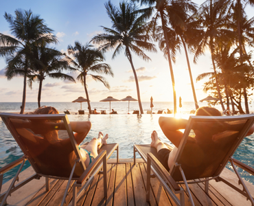 couple relaxing in resport pool lounge chairs