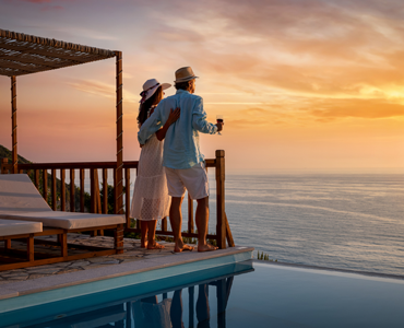 couple staring into the sunset at a resort pool oceanside